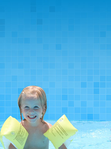 Little boy in an above ground pool with floaties The Recreational Warehouse Southwest Florida's Leading Warehouse for Spas, Hot Tubs, Pool Heaters, Pool Supplies, Outdoor Kitchens and more!